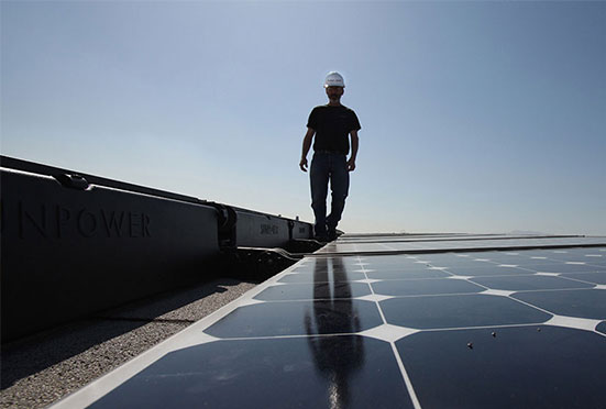 Solar installer on roof of commercial building.
